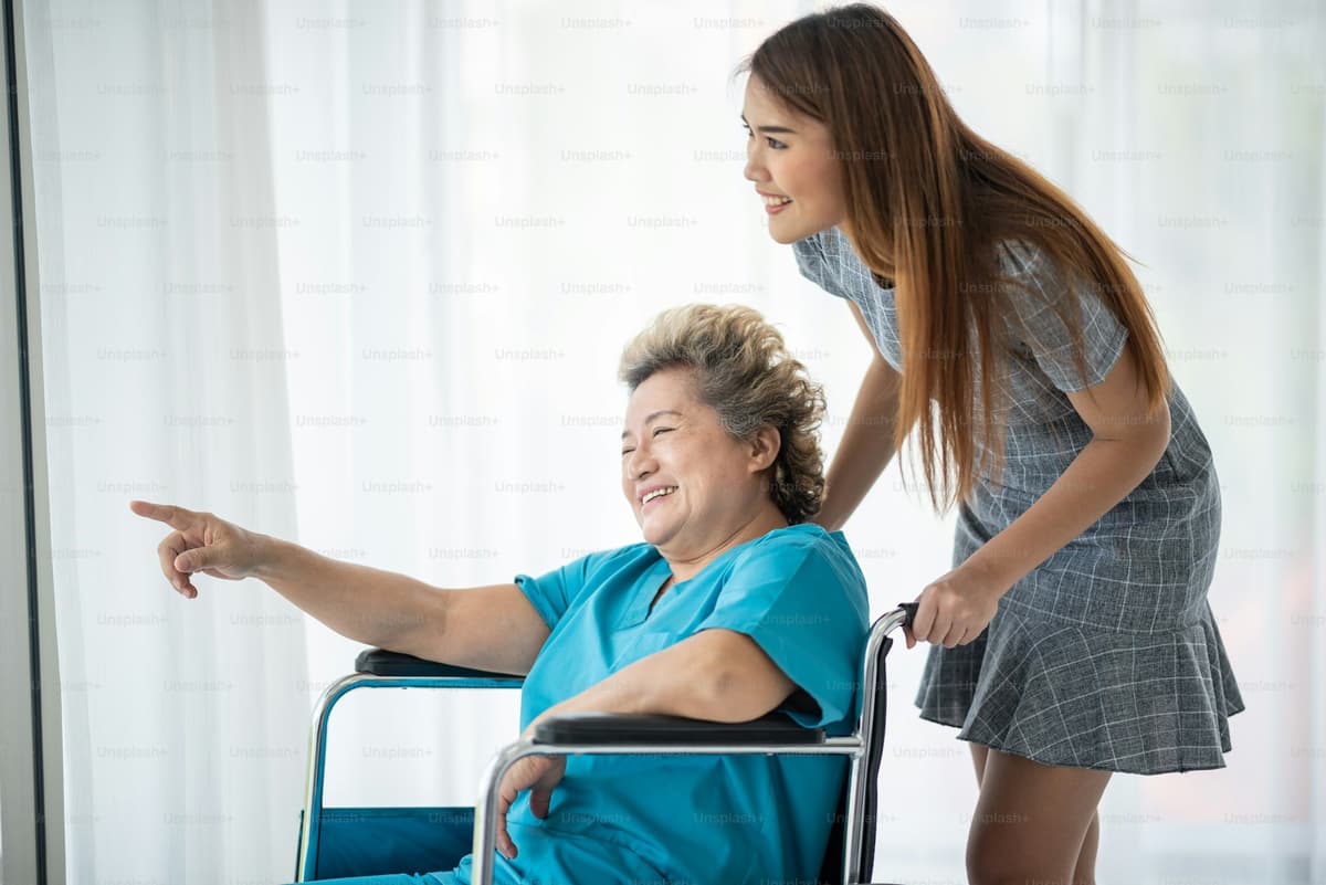 Caregiver smiling and talking to elderly woman
